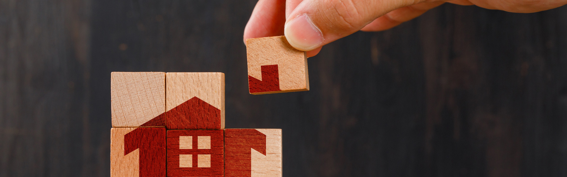 stay-home-concept-wooden-table-side-view-hand-holding-wooden-cube.jpg